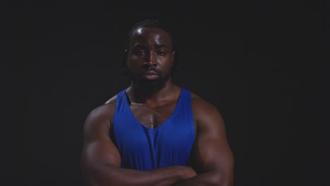 hombre negro musculoso posando con los brazos cruzados