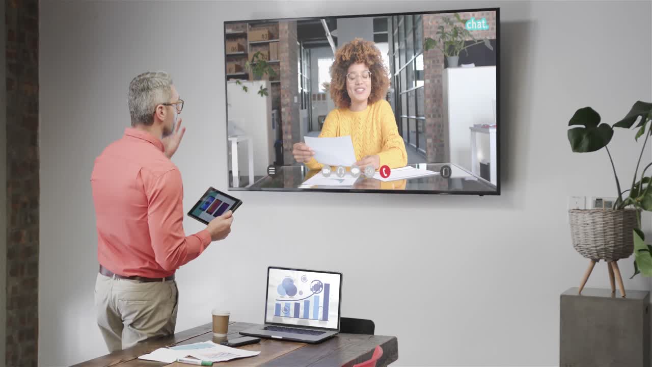 카우카시안 사업가 가 tv 스크린 에서 아프리카계 미국인 여성 동료 와 비디오 통화 를 하고 있다