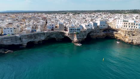 Cinematic-Aerial-View-over-Polignano-A-Mare-with-Narrow-Streets,-Rocky-Shoreline,-and-Crystal-Clear-Water,-Italy