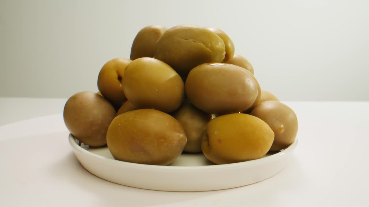 aceitunas verdes redondas en vinagre de grecia como fondo, vista de arriba. imágenes de alta calidad en 4k