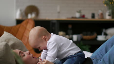 Junges-Süßes-Mädchen,-Das-Mit-Ihrem-Sohn-Auf-Dem-Bett-Spielt.-Eine-Junge-Mutter-Spielt-Mit-Einem-Baby-Auf-Dem-Bett.