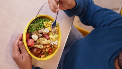 person eating a mixed salad bowl