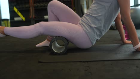 woman using a foam roller for leg stretching