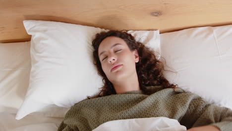lying in bed, woman holding head and experiencing headache or stress