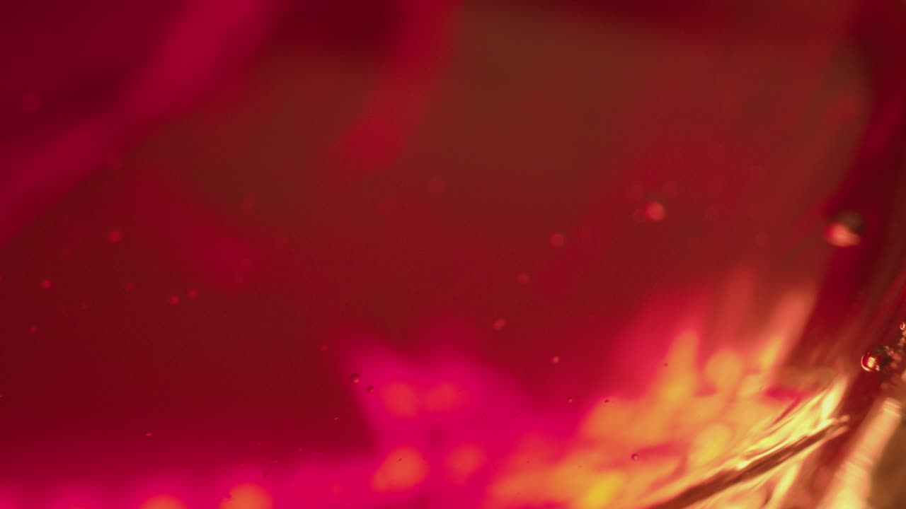 위스키 잔에 작은 거품이 있는 액체가 가볍게 흔들린다