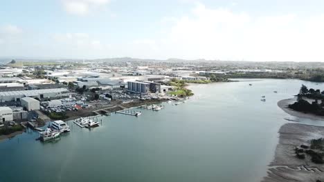 Antena-4k,-Volando-Hacia-Adelante-Lentamente,-Vista-De-Los-Suburbios-De-Auckland-Y-Fábrica-De-Barcos-En-La-Costa