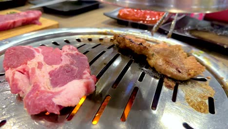 close-up of meat grilling on a korean bbq in bangkok. vibrant colors, dynamic camera angles, and sizzling action capture the culinary experience