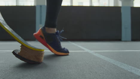 athlete with prosthetic running blade jumping on stadium track