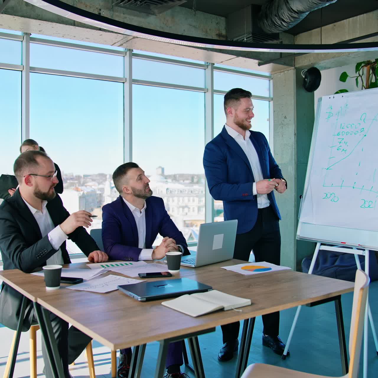 Panoramic office view with business people. Team of young entrepreneurs men and women work. City landscape through the office windows