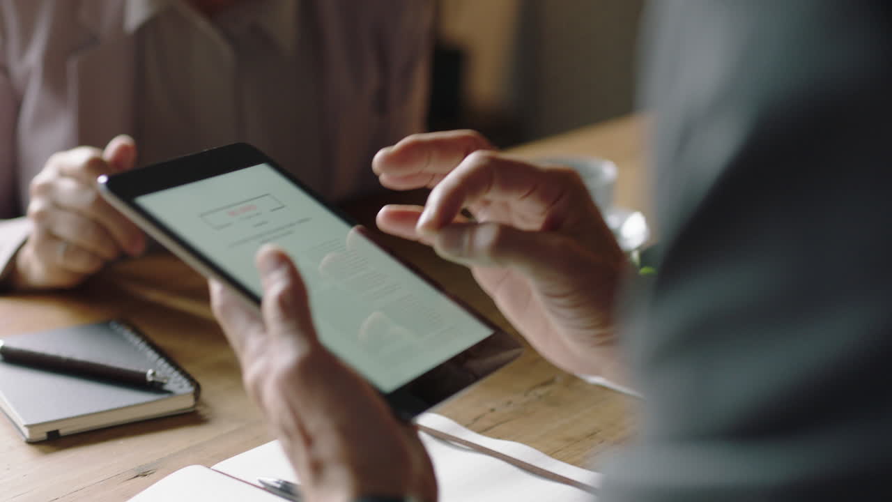 gente de negocios en un café usando tabletas trabajando en línea colaborando en tecnología móvil trabajando en red juntos socios intercambiando ideas discutiendo investigación de cerca