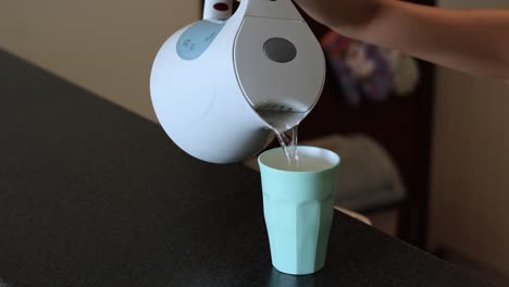 sequence of pouring water into a cup from a kettle