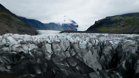 Icelandic-landscape-of-a-glacier-tongue-spurting-off-ice-cap,-drone-shot
