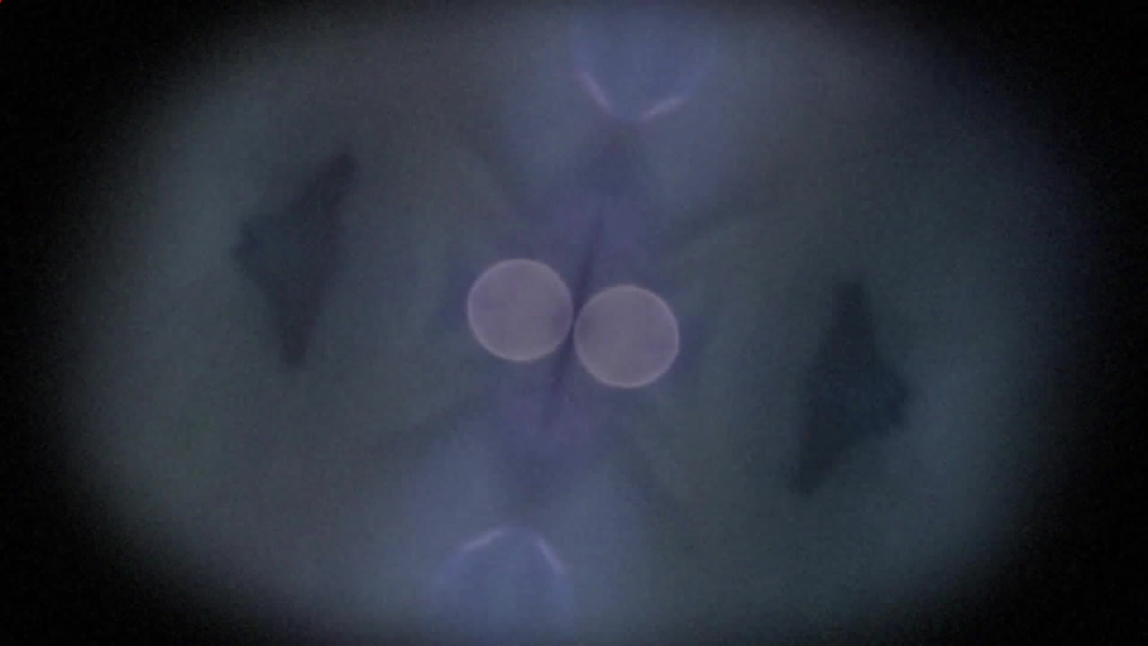 Abstract animation with symmetrical shapes and glowing circles over dark background