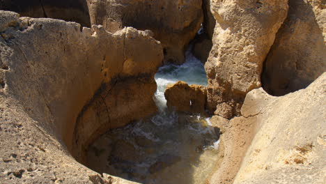 olas que se estrellan entre las brechas en los acantilados de piedra caliza del algarve, portugal