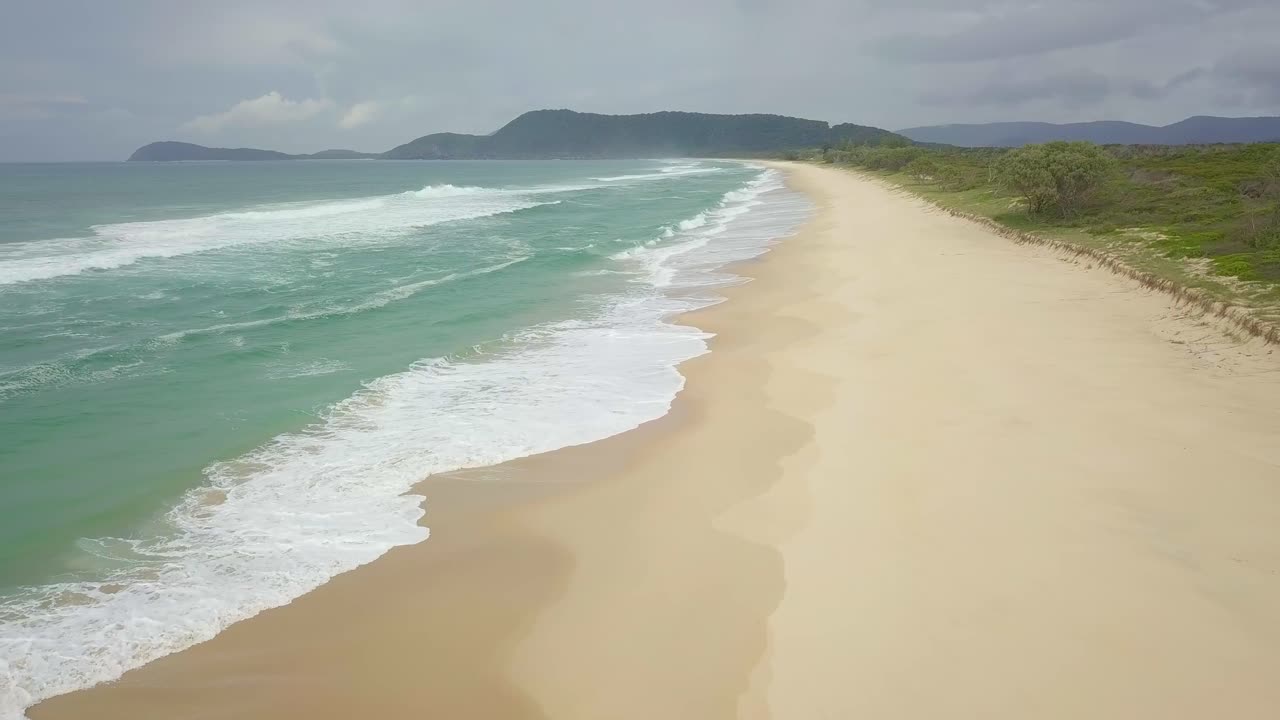 impresionante vuelo aéreo nublado por la mañana sobre playas y olas aisladas, australia