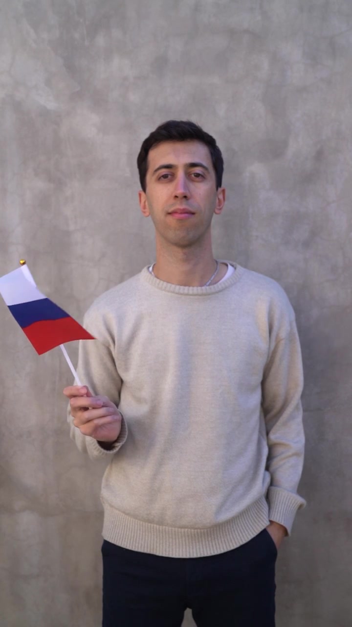Uomo adulto che sventola la bandiera della Russia. Movimento lento. Ripresa verticale.