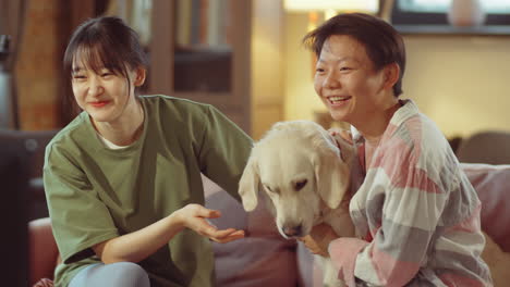 happy asian women and dog eating popcorn and watching tv at home