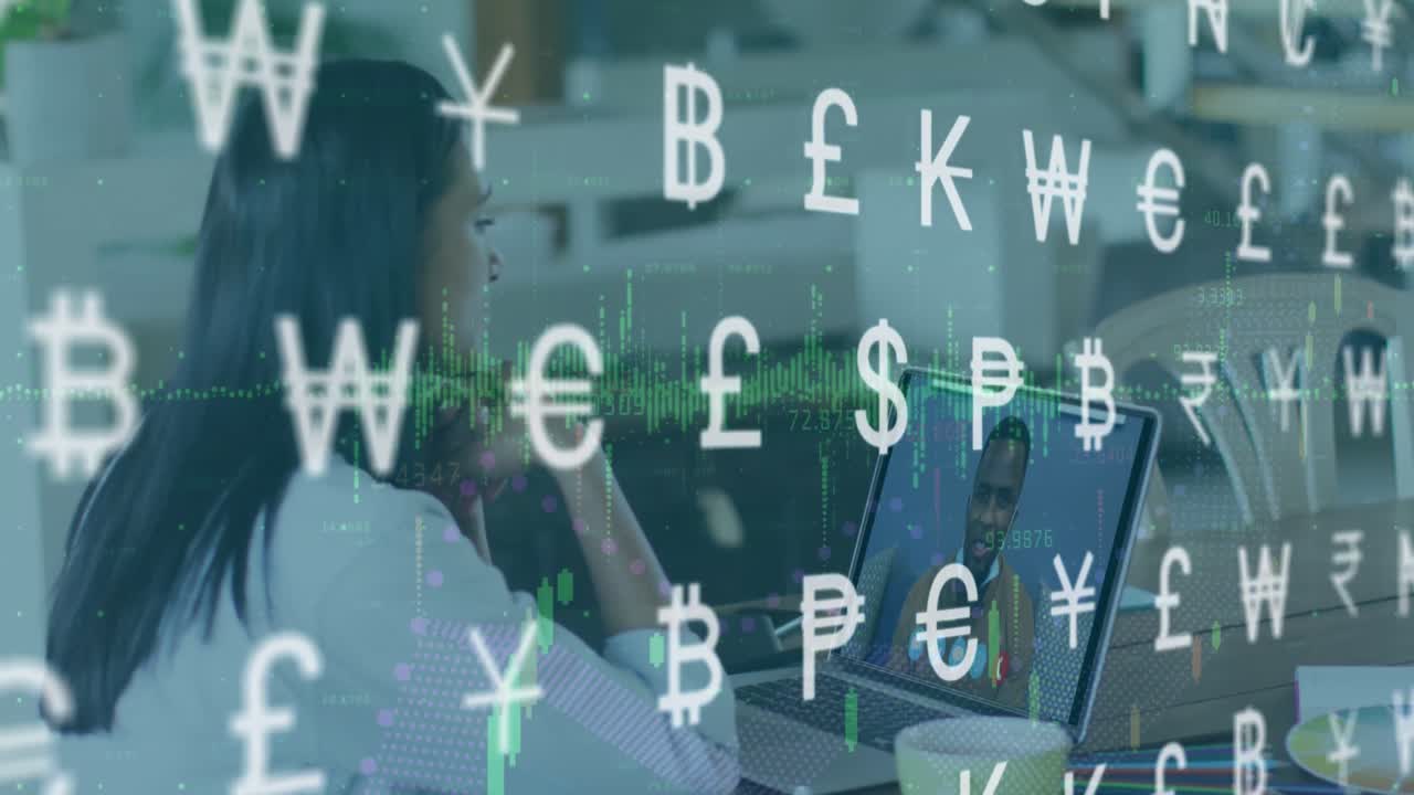 animación de símbolos de moneda contra una mujer biracial haciendo una videollamada en una computadora portátil en la oficina