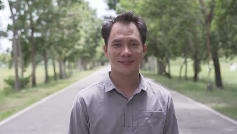 good looking filipino businessman smiling while walking in the empty road toward camera in the philippines