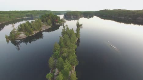 Orbital-aerial-shot-around-forested-island-in-Charleston-Lake,-Ontario,-Canada-at-sunset