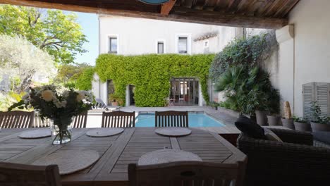 slow establishing shot of a beautiful villa garden with a pool and furniture