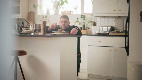 man eating dinner in a kitchen