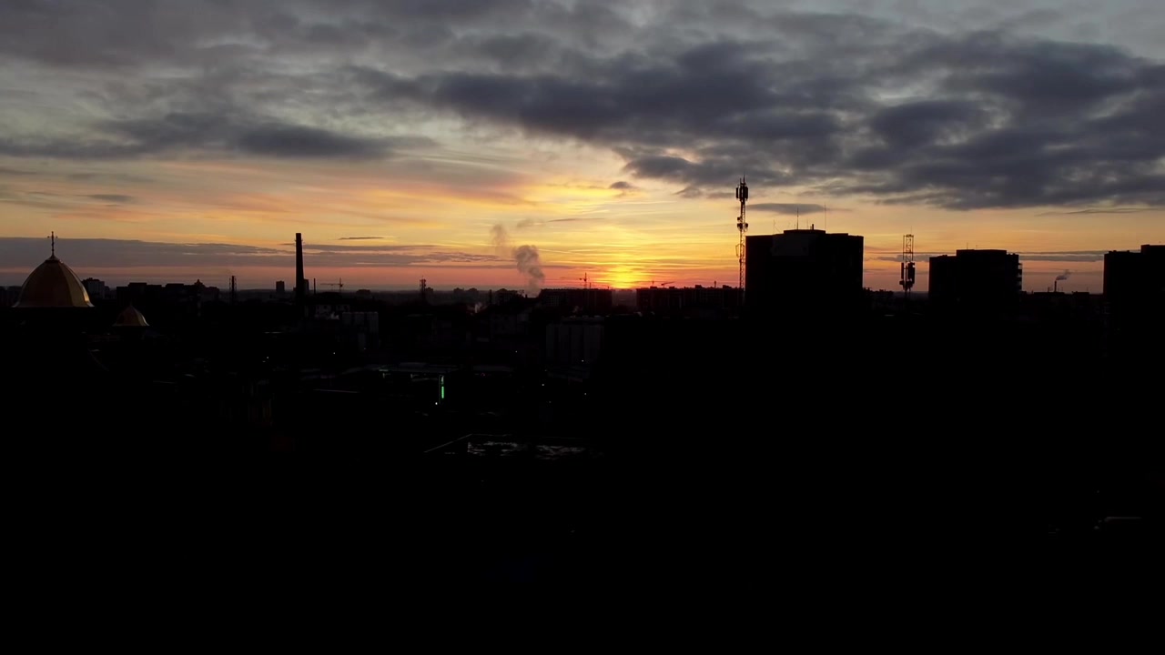 Vista aérea de un dron volando sobre la ciudad. Atardecer en el cielo