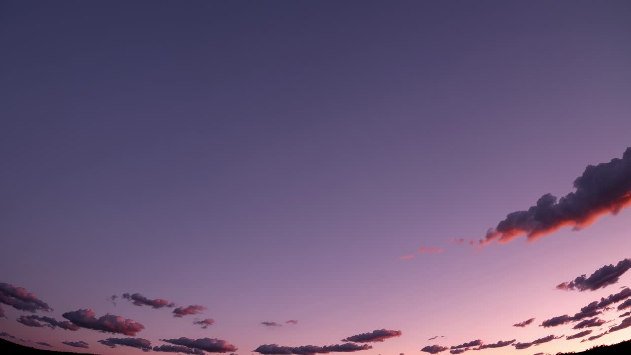 Time-lapse video of a sunset sky with scattered clouds, captured from a low-angle perspective