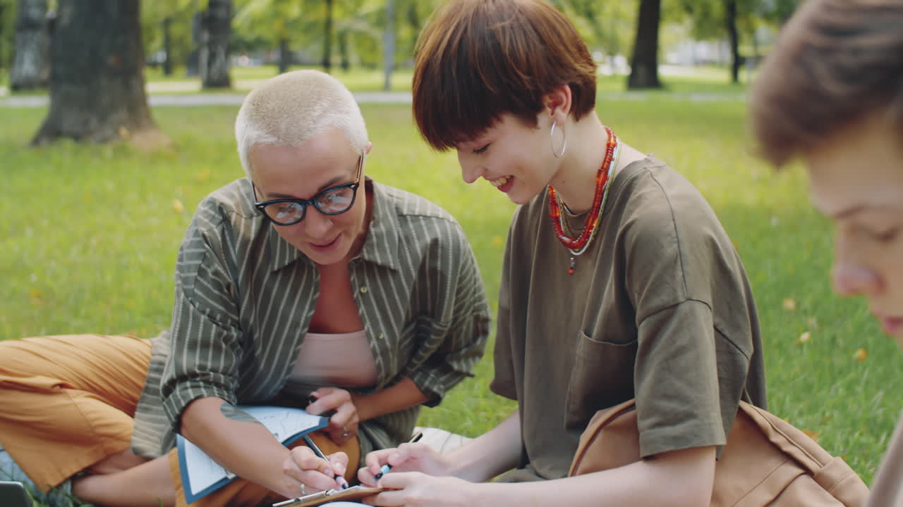 maestro ayudando al estudiante durante la lección al aire libre en el parque