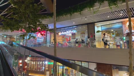 night view of a modern shopping mall with restaurants and food courts