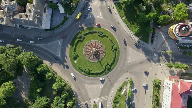 vista aérea de 4k de uma estrada de rotunda com carros circulares em uma pequena cidade europeia em um dia ensolarado