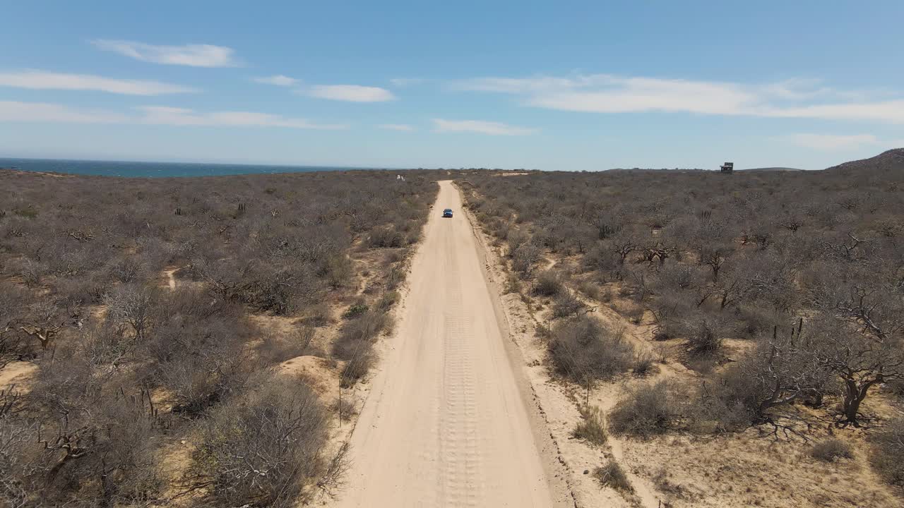 Blue Truck Driving on a Desert Road