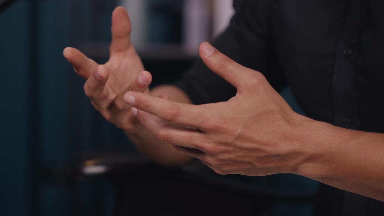 Uomo che gesticola con le mani mentre parla in un contesto professionale