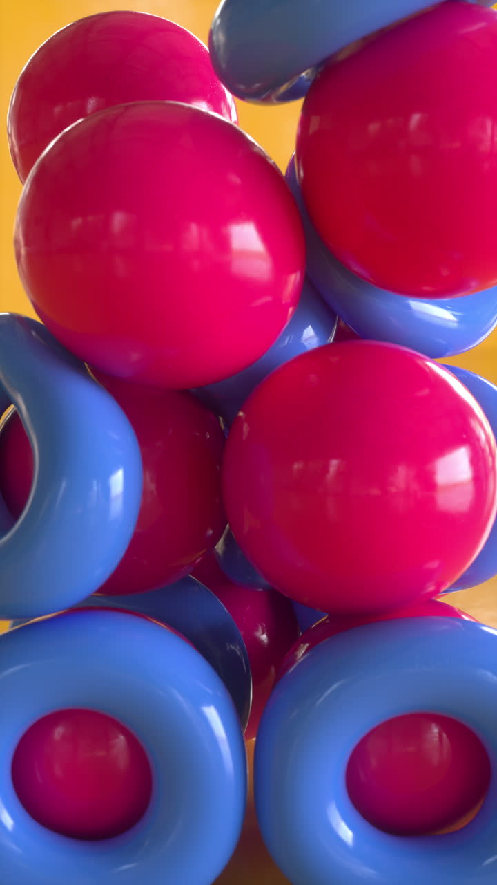 Rubber balls and rings falling in heap on yellow. Satisfying 3d animation. Vertical orientation