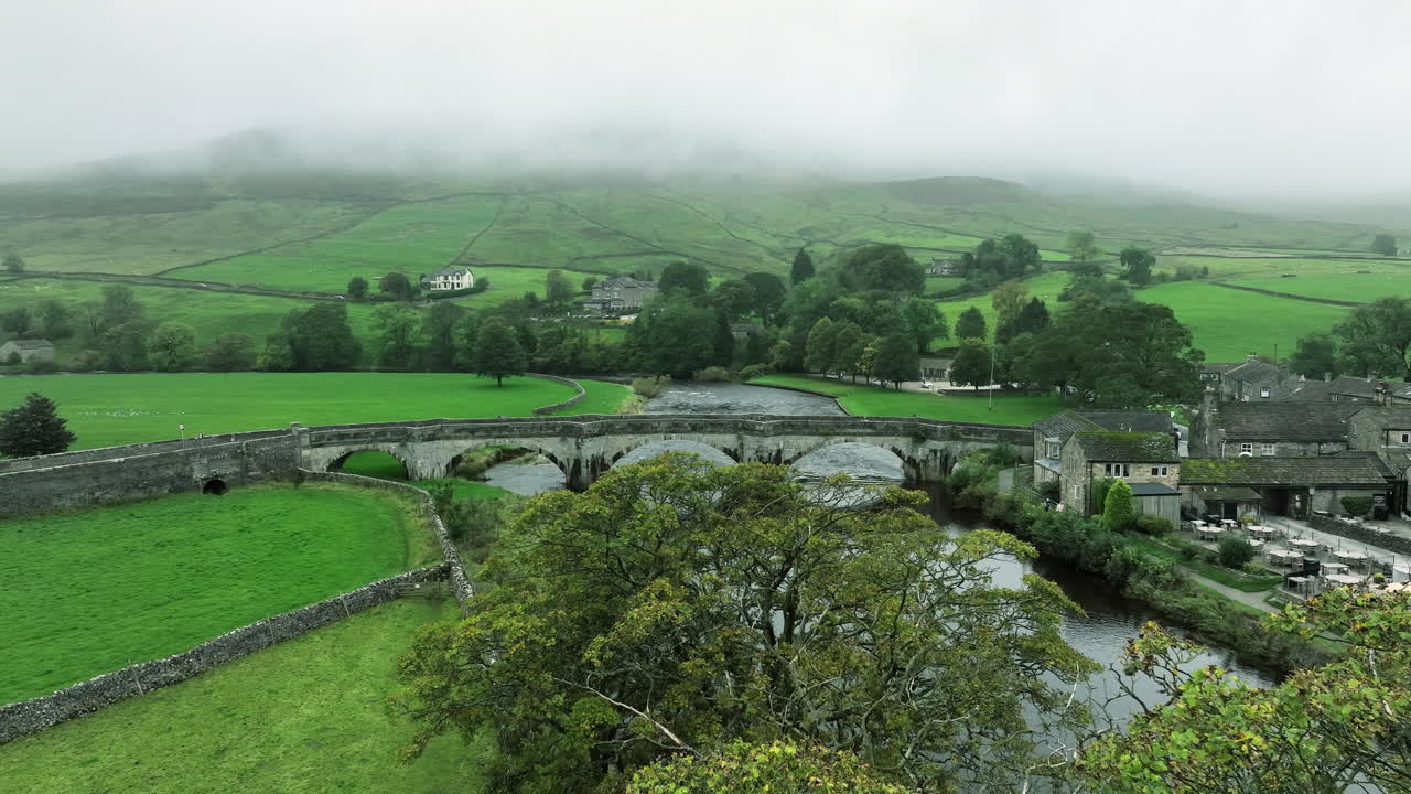 lentamente hacia adelante y por encima de los árboles hacia el puente en nublado, yorkshire, reino unido