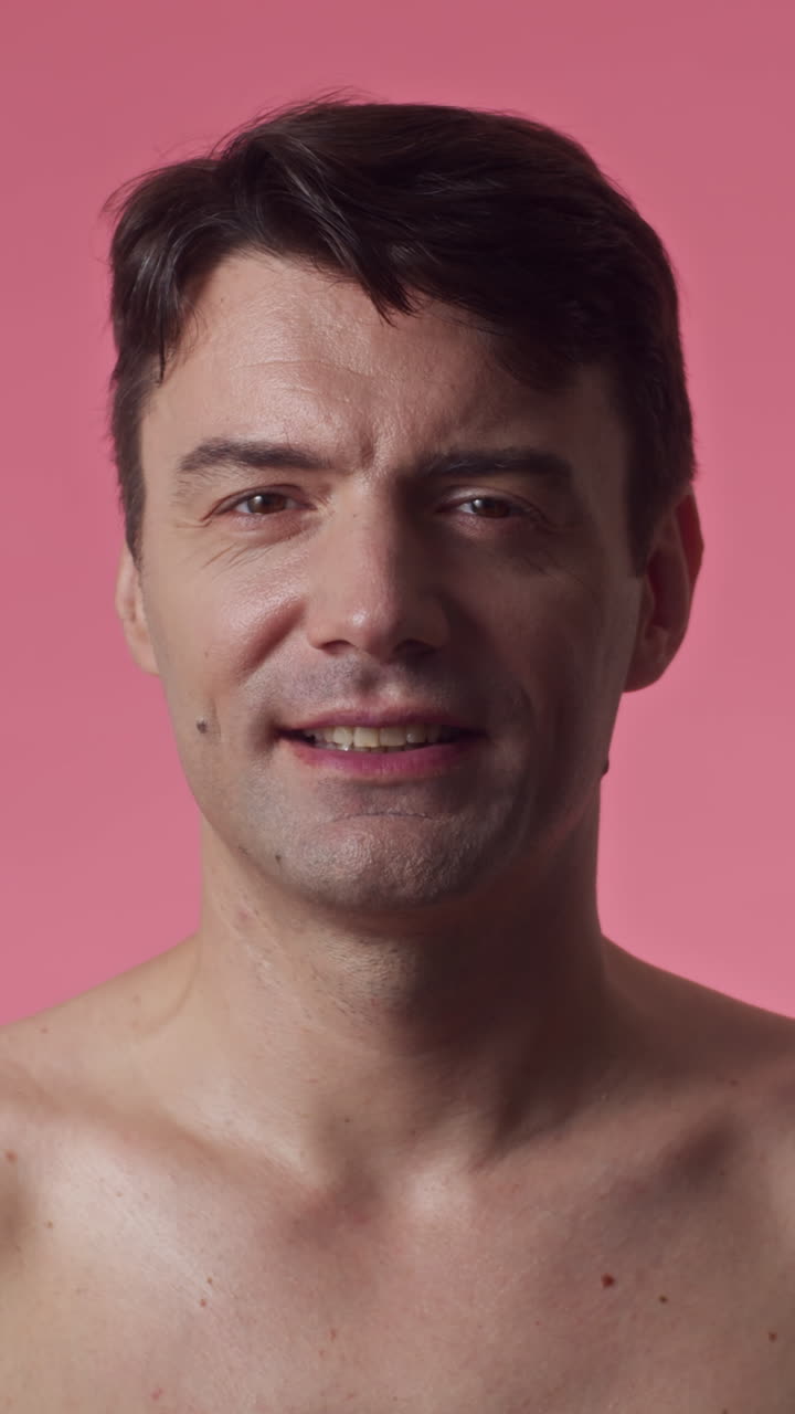 Middle-aged Man Smiling at Camera on Pink Background