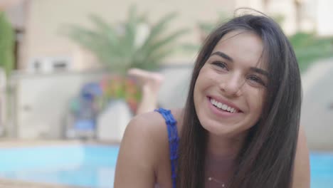 increíble mujer joven tendido en el borde de una piscina