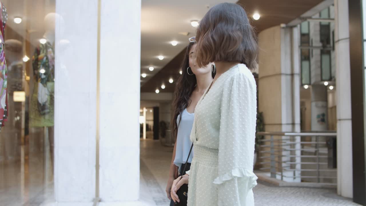 상점 창 근처에 서서 이야기하는 아름다운 젊은 여성