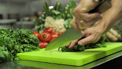 Parsley-cut-in-kitchen-restaurant-on-vegetable-background-by-unrecognizable-chef