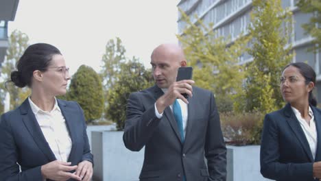 medium shot of business colleagues walking together at office building, talking and discussing project details