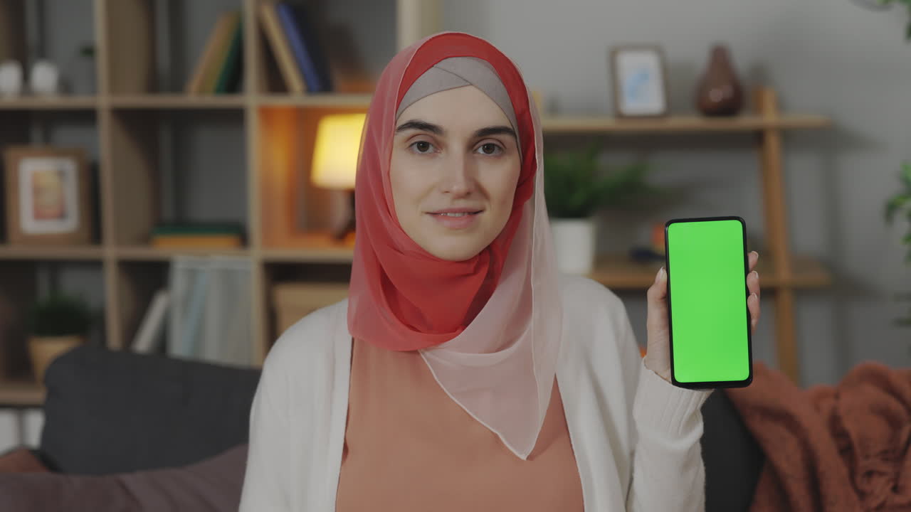 Woman in Hijab Holding Smartphone with Green Screen