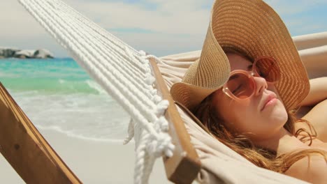 Vista-Lateral-De-Una-Mujer-Caucásica-Relajándose-En-Una-Hamaca-En-La-Playa-4k