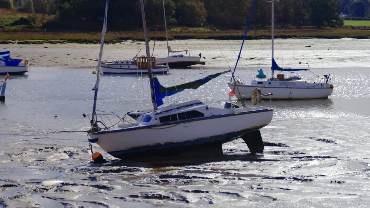 toma de mano de un barco en el barro durante la marea baja en un río