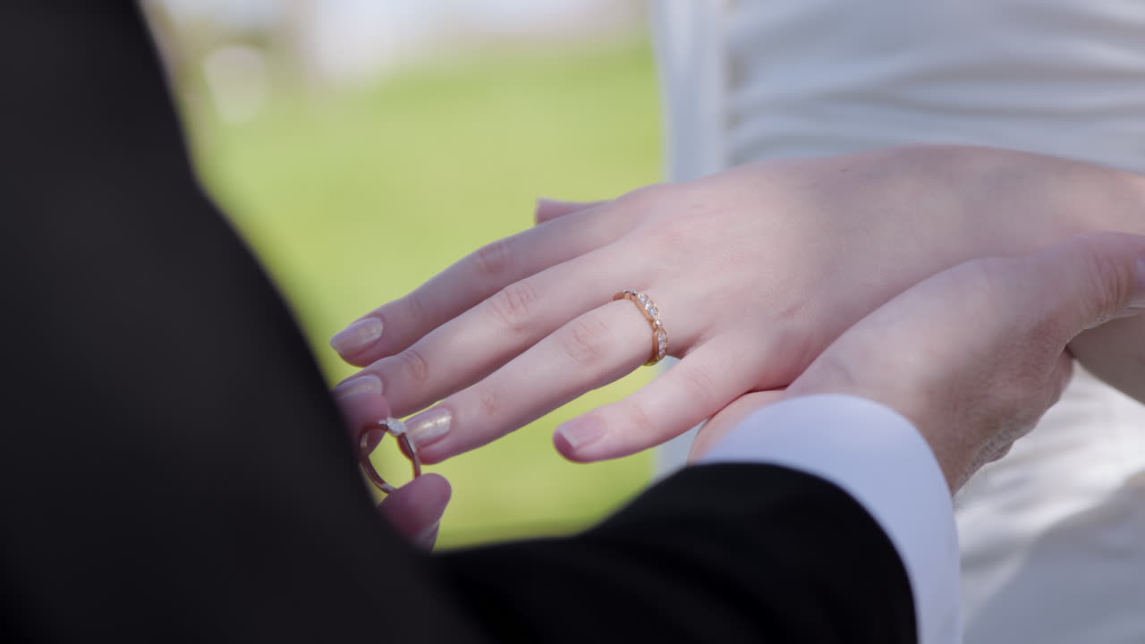 Cropped View Of A Groom Wearing A Golden Wedding Ring On The Bride's Finger. Selective Focus Shot