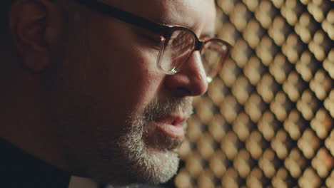 Priest Praying with Eyes Closed in Confessional Booth