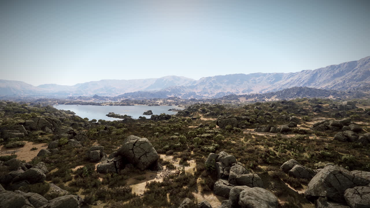una vista panorámica de un paisaje desértico con montañas, un lago y rocas