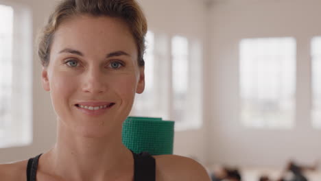 Retrato-Hermosa-Mujer-De-Yoga-Sonriendo-Con-Confianza-Mujer-Caucásica-Disfrutando-De-Un-Estilo-De-Vida-Saludable-Con-Gente-Practicando-En-El-Fondo-Del-Gimnasio