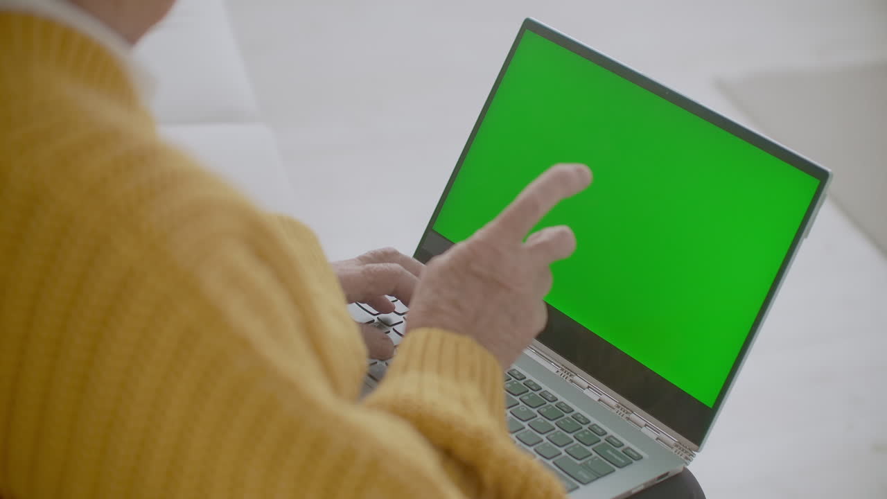 la abuela habla mirando por encima de su hombro mirando la pantalla verde con chromakey