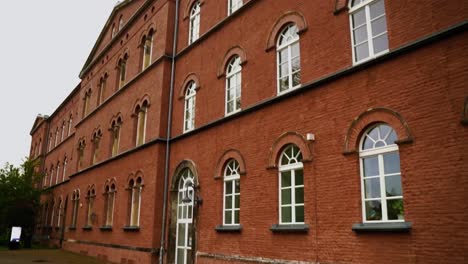 pan-up-to-a-brick-house-wall-with-many-floors-and-large-white-windows