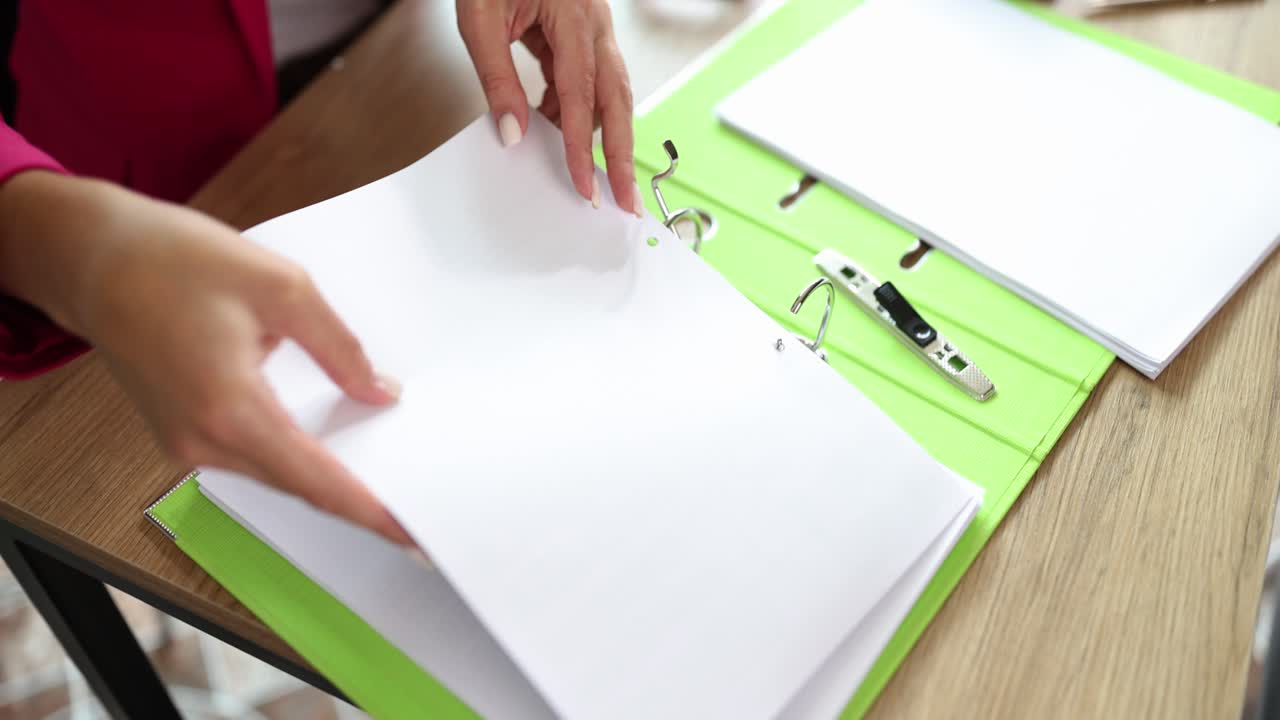 Person organizing documents with office supplies